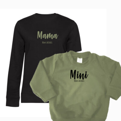 zwarte sweater met opdruk mama en est. geboortejaar in leger groene kleur van mini sweater. Mini sweater is leger groen met mini, est.( jaartal geboorte) in zwarte opdruk.